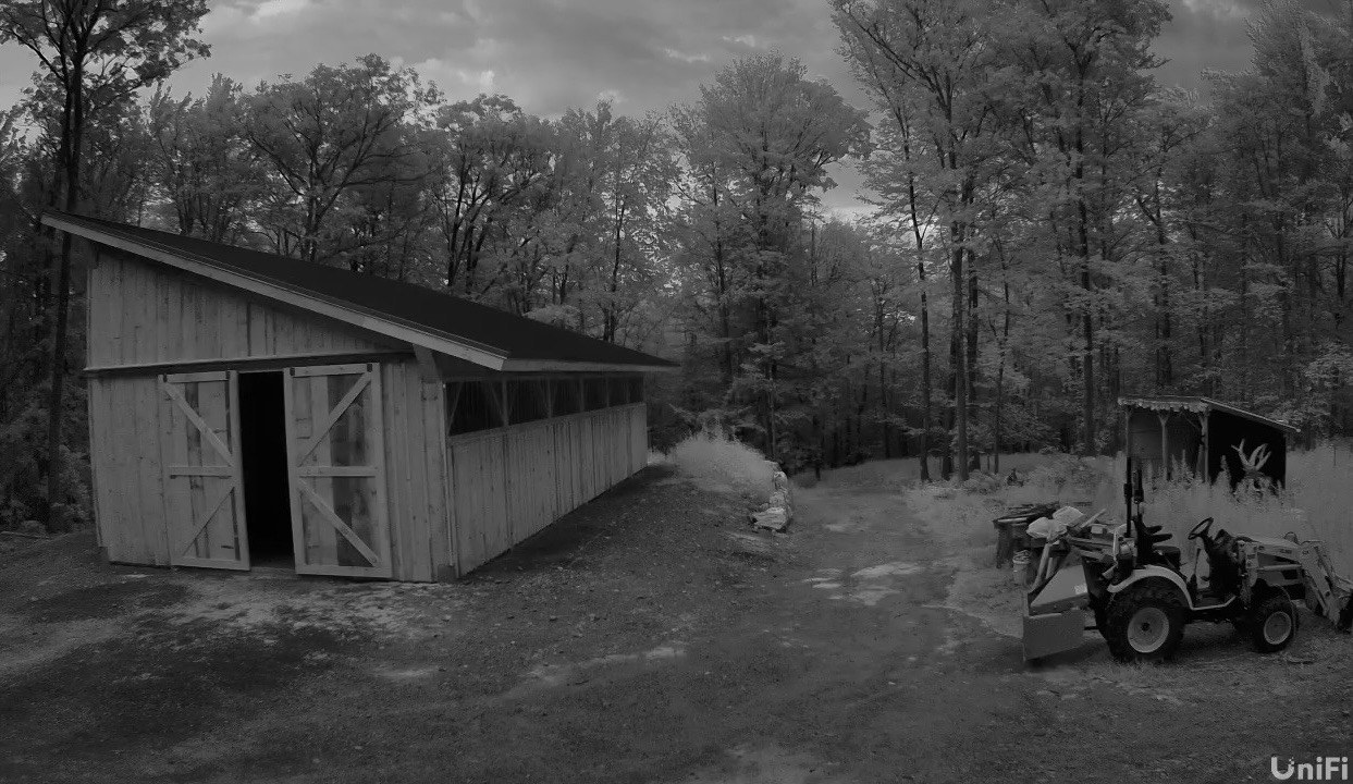 Night-vision camera view of the wood shed and tractor